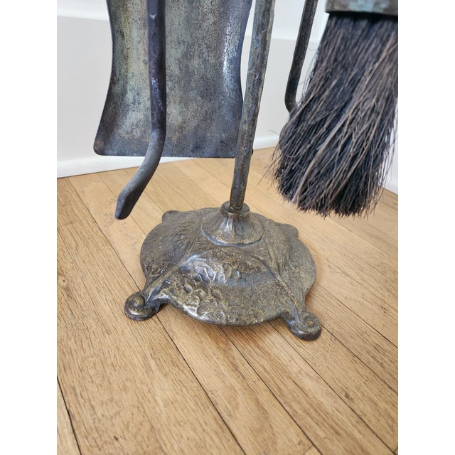 This set of fireplace tools appears to be made of cast brass, but the coloring is slightly different on each piece. It has...