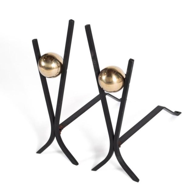 Pair of Donald Deskey fireplace andirons manufactured by Bennett MFGA. The wrought iron pieces have cast brass spheres....