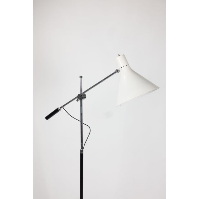 Single-arm floor lamp, designed by Angelo Lelii for Arredoluce. A chrome counterbalance arm carries a white enameled...
