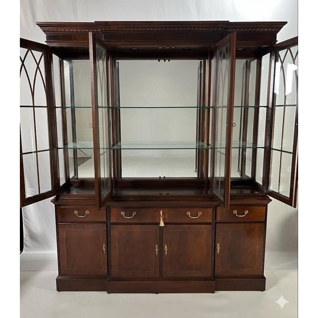 Stately Georgian-style breakfront china cabinet by Ethan Allen. Expertly crafted in the United States, this piece features...