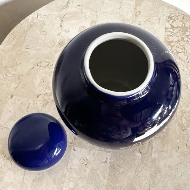 This vintage Japanese ginger jar features a striking cobalt blue glaze accented with elegant hand-painted gold characters...