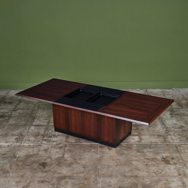 Stunning rosewood coffee table with bar storage for E. Pedersen & Son Denmark, c.1950s, Denmark. The table features a...