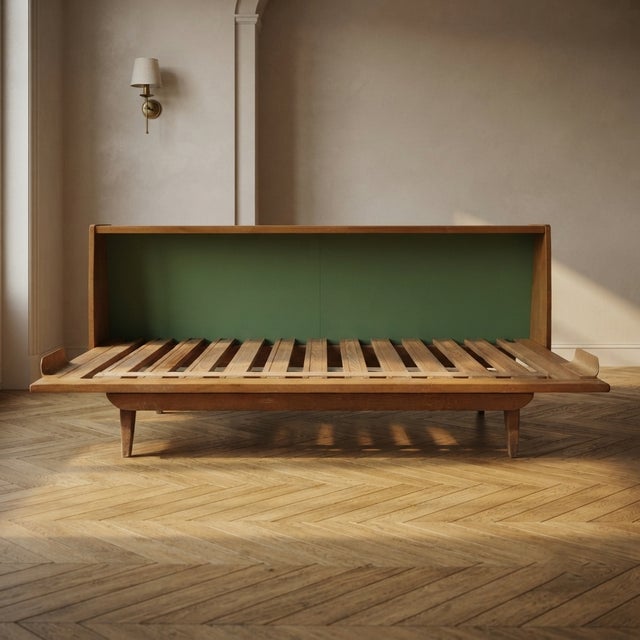 A practical mid-century folding sofa bed frame crafted from wood, featuring clean lines and a functional extendable...
