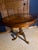 Beautiful traditional-style round pedestal table featuring a striking multi-wood sunburst/starburst inlaid top with a...