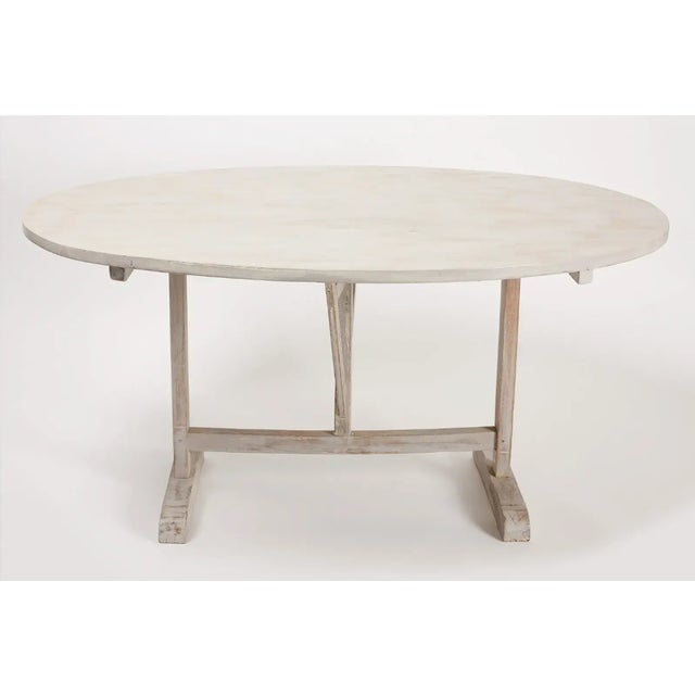 Vintage French tilt top wine table, in an antique white finish. Poplar top and oak base. Age unknown, top was added at a...