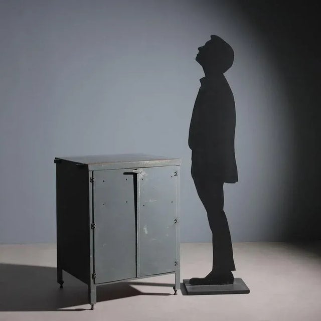 Workshop cabinet with two hinged doors and a double wooden shelf. Made of gray enameled metal, restored in our workshop....