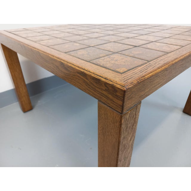 Vintage coffee table from the 60s and 70s, legs and structure in brutalist oak wood, square ceramic top in gold and brown...