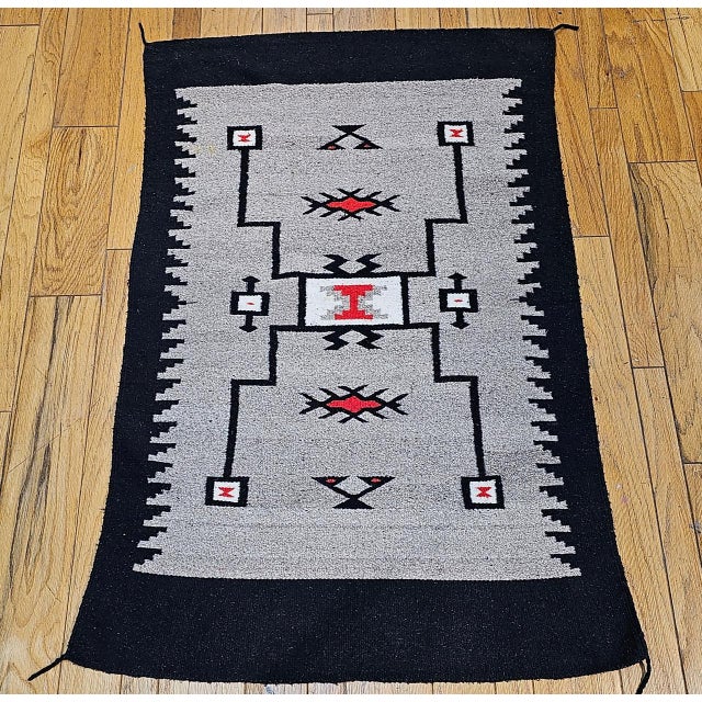 An exceptional example of early 20th-century Native American textile art, this finely woven Navajo rug�circa...