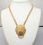 1970s goldtone lion doorknocker with round clear rhinestone eyes pendant on a chain with spring ring clasp. Marked...