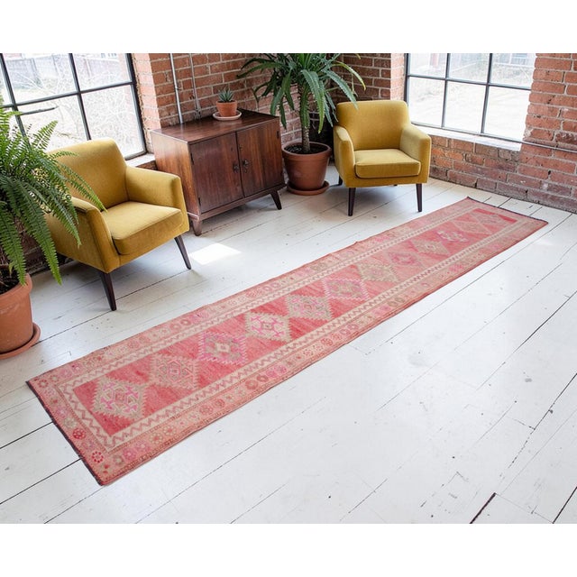 An exceptional example of mid-20th-century textile art, this vintage Turkish runner rug was hand-knotted by village...