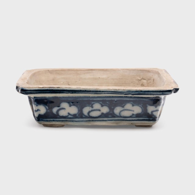 Richly painted in the blue-and-white manner, this shallow porcelain dish is a 19th-century Chinese bulb pot, used for...
