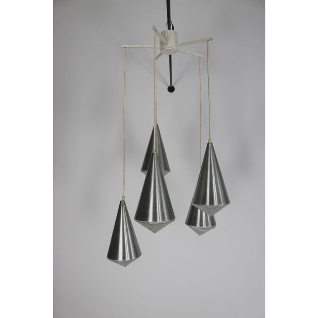 This decorative cascade lamp from the 1970s consists of five conical shades made of brushed aluminum, complemented by...