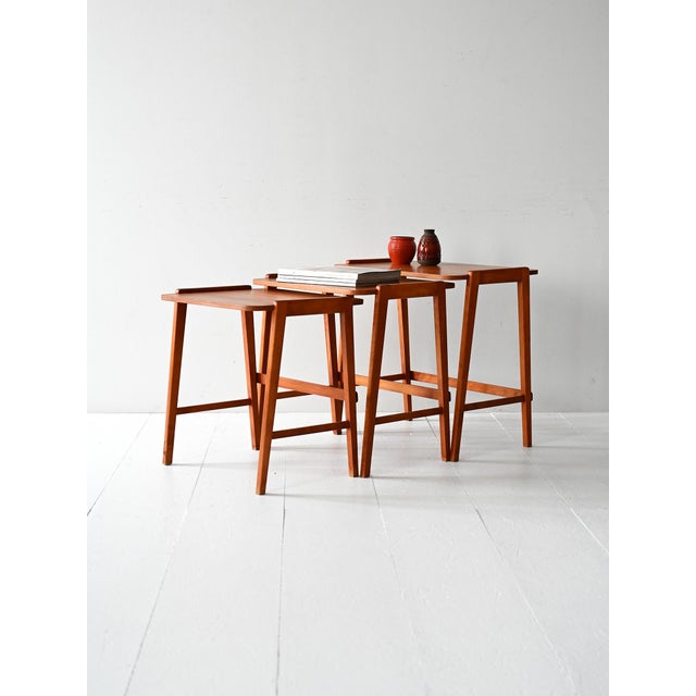 Set of three mahogany nesting tables with lateral edges, Scandinavian production from the 1960s. Trio of vintage...