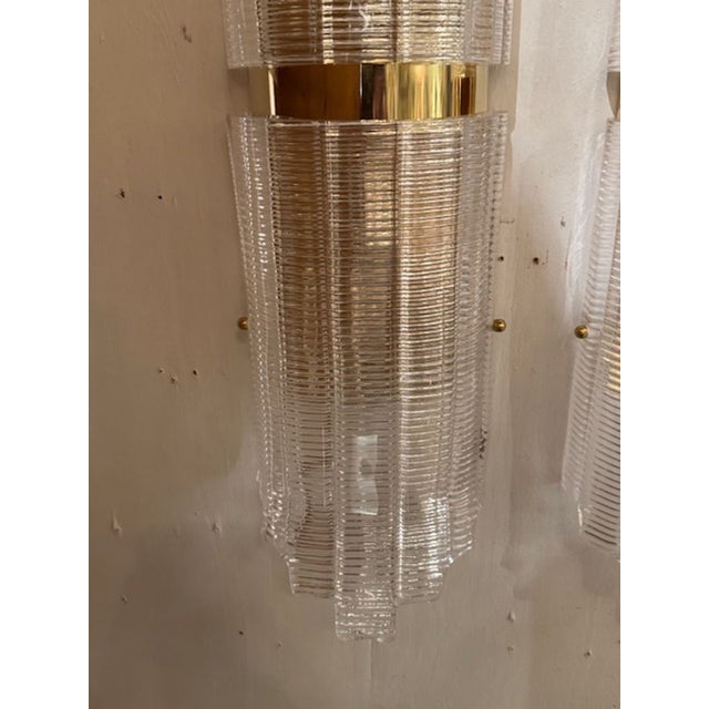 The large-Scale Ribbed Murano Glass and Brass Tube Form Sconces are a stylish and elegant addition to any home decor....