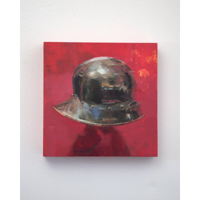 This artwork features a striking depiction of a metallic helmet set against a bold red background. The glossy surface of...