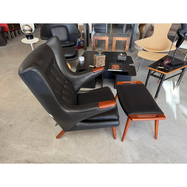 A stunning black leather papa bear chair and ottoman designed by Hans J. Wegner and manufactured by A.P. Stolen. Both...