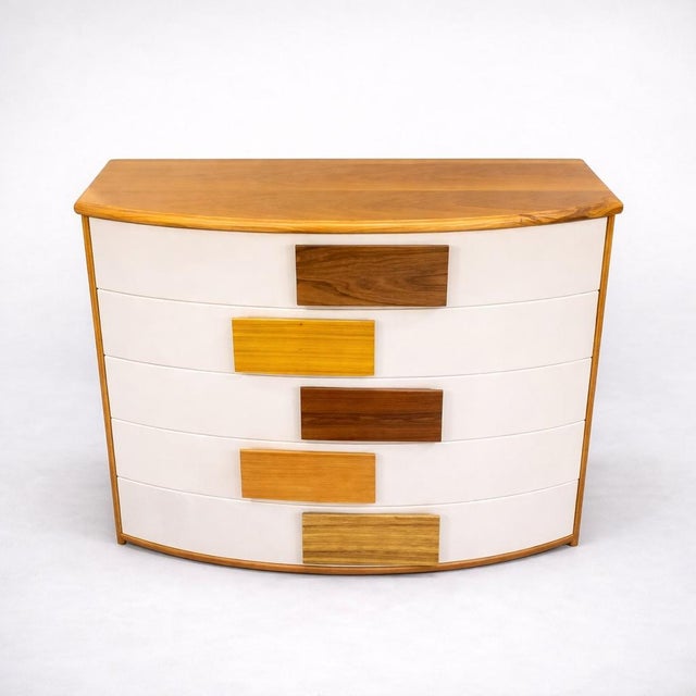 Five-drawer chest of drawers with a curved front. The chest of drawers features a rounded silhouette on the front, a...
