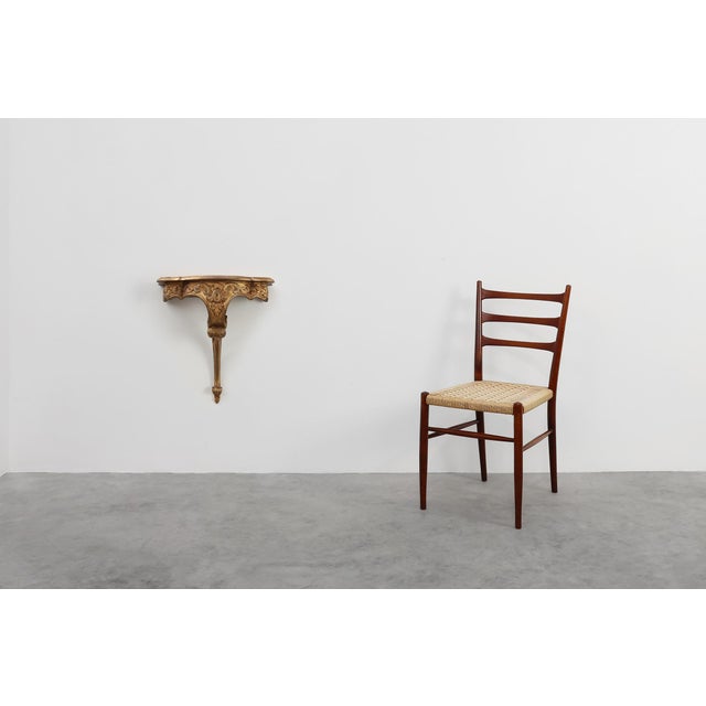 A richly decorative Louis XV‑style giltwood wall console, crafted in France and shaped with the fluid elegance...