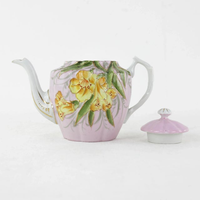 Add a touch of vintage elegance to your collection with this charming pink porcelain teapot, adorned with vivid yellow...