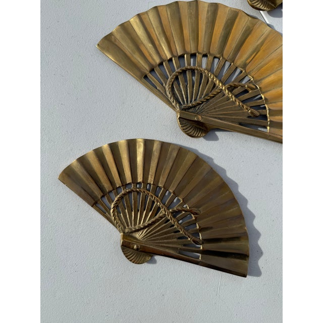 Collection of three mid century modern brass fan wall hangings. Small, medium, and large size with decorative rope...