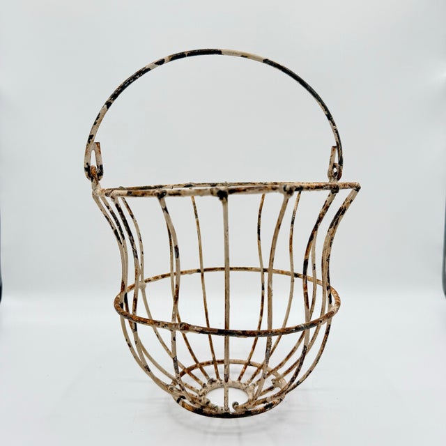 A beautifully timeworn vintage wire egg basket with original white paint worn to the perfect level of rustic charm. The...