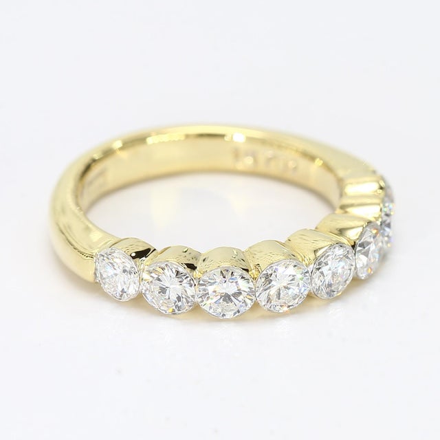 This is an 18k yellow gold band with eight bezel set diamonds each weighing ~0.17ct and is graded at VVS2/F. - Stone Info...