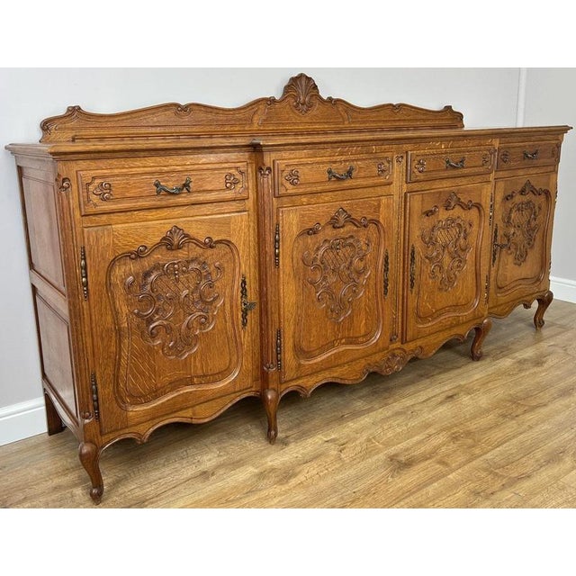 This elegant Vintage French Louis sideboard is a beautifully crafted oak piece, featuring rich natural grain, finely...