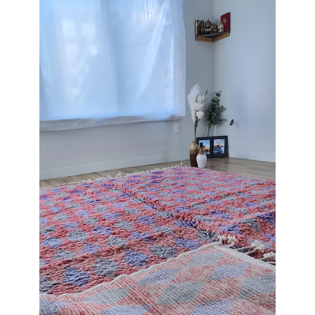 A large Moroccan rug hand-knotted in wool by Berber artisans, with a repeating diamond checkerboard across the full field...