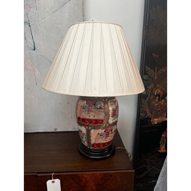 Each lamp features a hand-painted porcelain body adorned with "Six Ladies" and floral motifs in a vibrant Famille Rose...