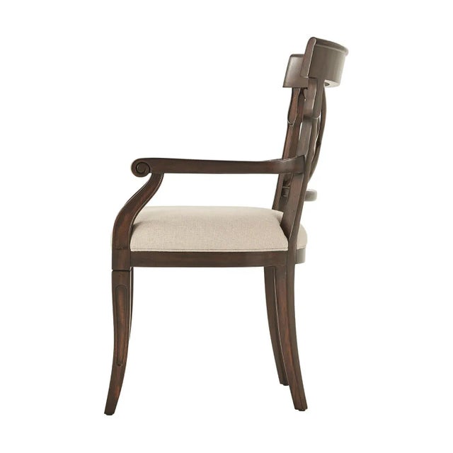 A Provincial armchair, the curved bar toprail above an "X" back and upholstered seat, on carved sabre legs. The original...