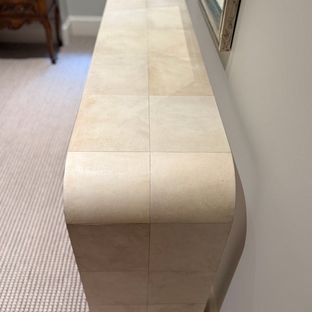 RH Lucien Parchment Console A minimalist silhouette combined with luxurious materials. A waterfall shape is wrapped in...