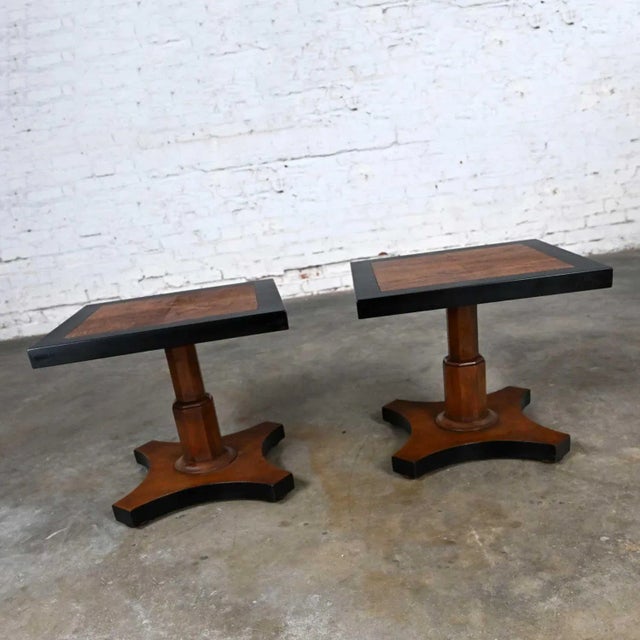 Fabulous vintage Baker Furniture Campaign style pedestal end tables, a pair with a black and natural finish. Beautiful...