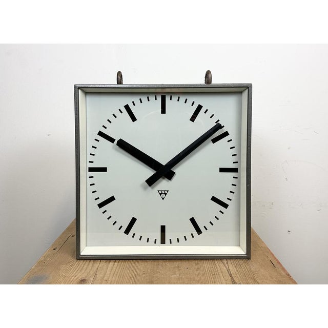 This square double-sided railway, school or factory clock was produced by Pragotron, in former Czechoslovakia, during the...