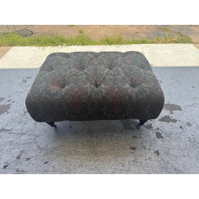 Vintage tufted upholstered ottoman with floral fabric and turned wood legs. Traditional bench, footstool, or coffee table...