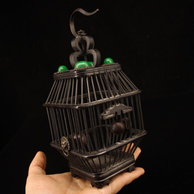 This is a finely crafted wooden cricket cage, constructed from dark, polished ebony wood. The cage features a square,...