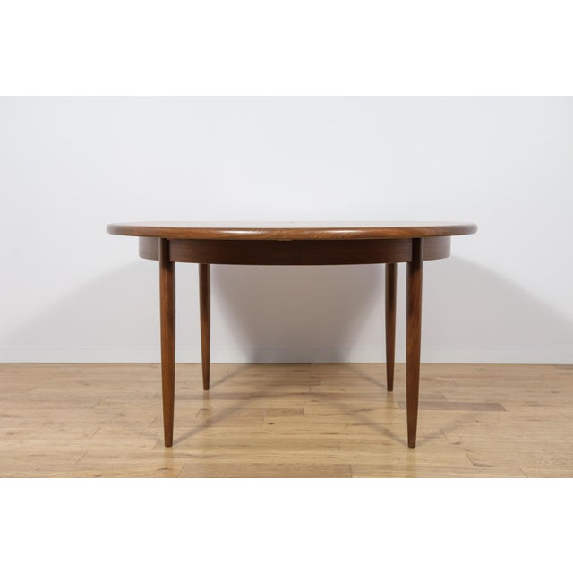 This round extendable dining table was produced by G-Plan in the 1960s. The table has profiled reinforced edges of the...