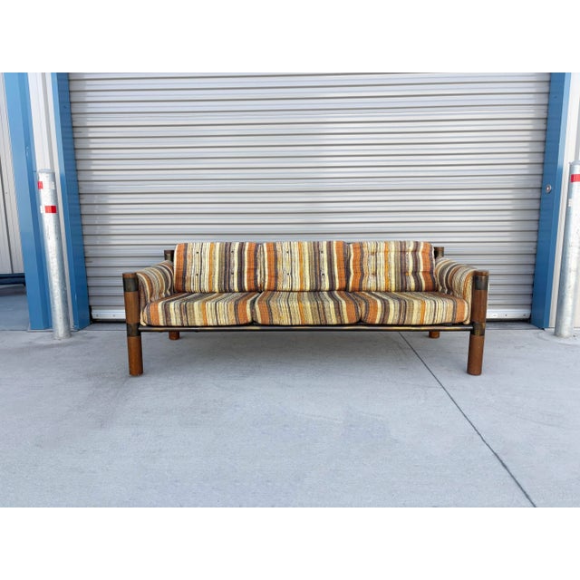 This striking 1970s mid-century modern safari-style sofa combines bold architectural structure with quintessential vintage...