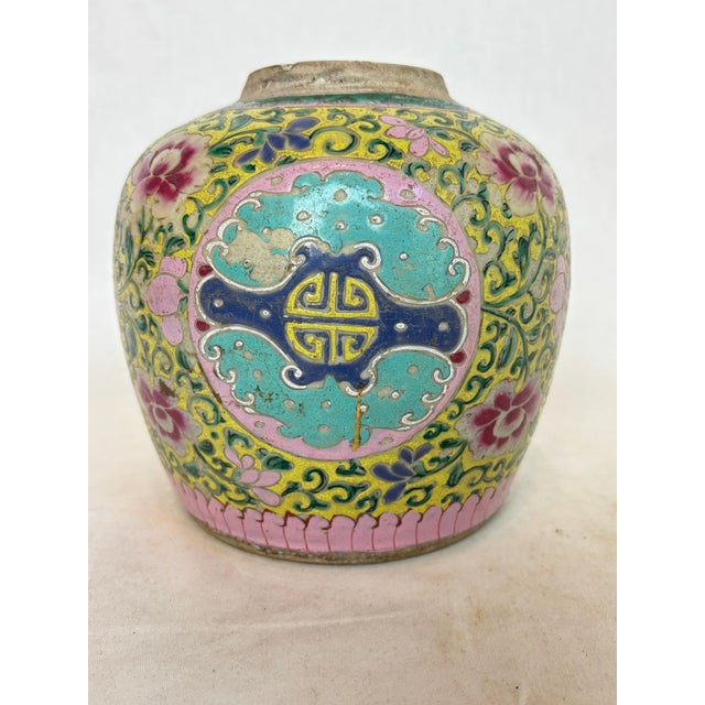 This lovely imperial yellow jar has pink and purple floral designs with green leaves.