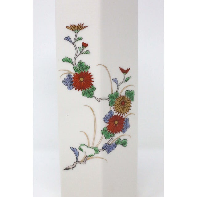 A vintage, Japanese porcelain vase with a white finish, hexagonal form, gold details, and colorful hand-painted floral...