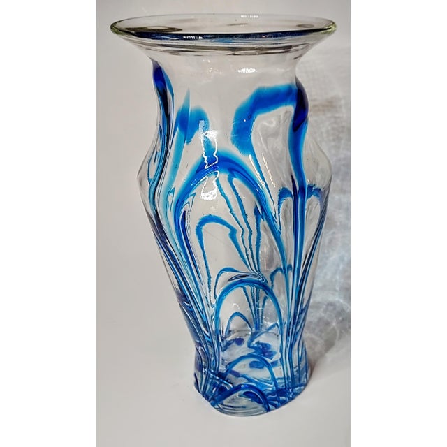 This vibrantly blue accented base was hand blown , then strips of blue glass were applied while it was still hot. The...