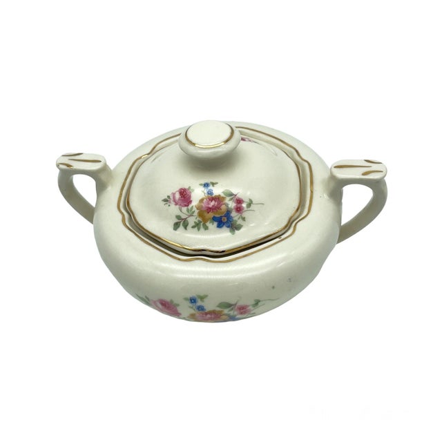 Beautiful Victorian styled sugar bowl with lid featuring floral motif and 24K Gold details around rim and handles.