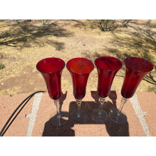 This is a lovely set of 4 ruby red ribbed champagne flutes. they have a ruby red ribbed bowl with a clear base and long...