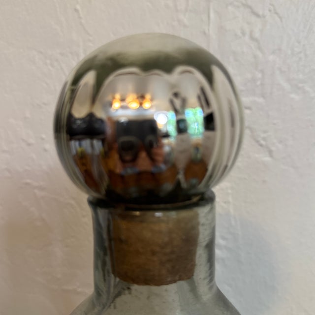 Beautiful and unique vintage hand blown green rain glass bottle with a mercury glass and cork stopper. All 3 sides are...