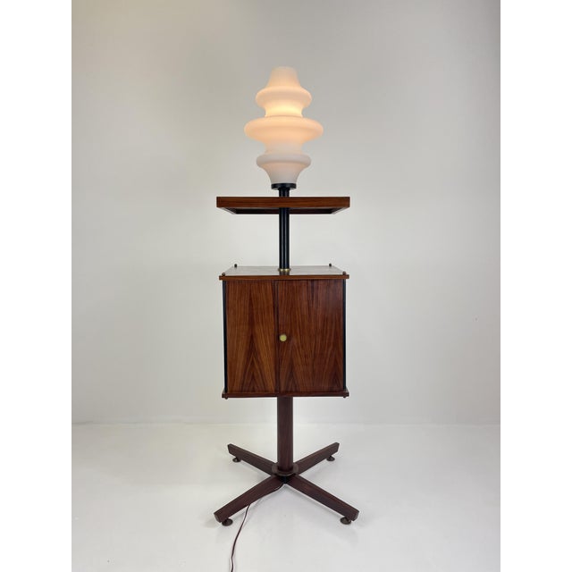 A 1960s-era illuminated rotating cabinet in the style of Ico Parisi, a refined example of Italian design combining formal...