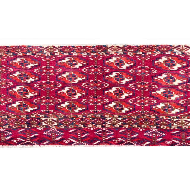 A beautiful early 20th century Persian Turkmen Take rug with all-over styled floral medallions woven in orange and white,...