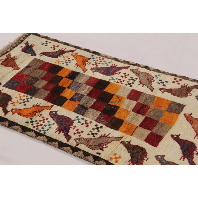 Hand-knotted in wool circa 1950-1960, this 3x5 vintage Persian Gabbeh rug is an enchanting entry in Rug & Kilim’s curation...