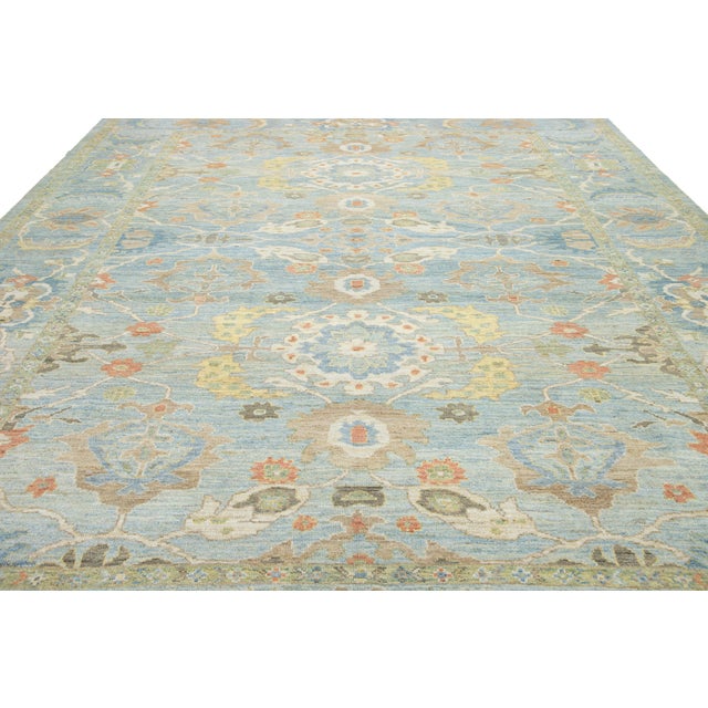 Discover the elegance of this exquisite hand-knotted Sultanabad wool rug, featuring a calm light blue background enhanced...