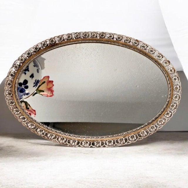 vintage ornate vanity tray with a gold filigree frame.This tray is typically constructed with a brass or metal frame and a...