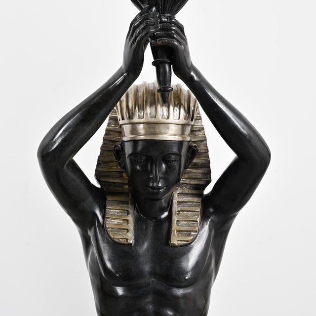 A pair of Egyptian-inspired floor lamps by Maison Jansen, circa 1970, depicting a man and a woman in a hieratic pose,...