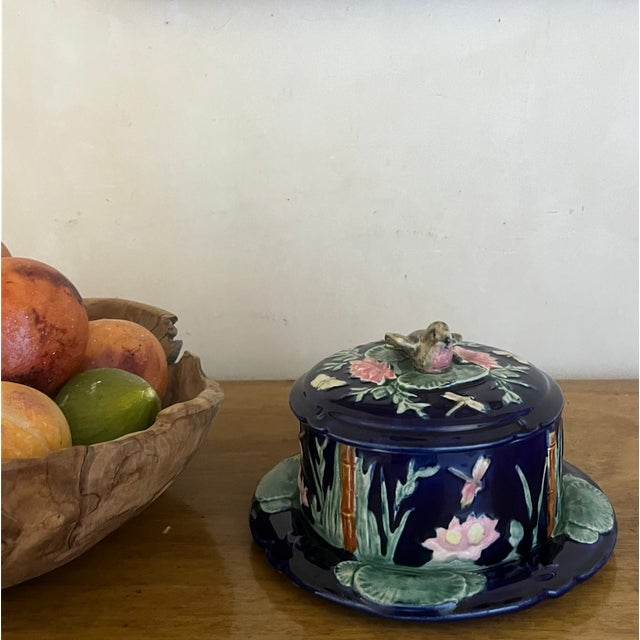 Antique lidded butter dish made in England by Forester, The cobalt background is overlayed with relief molded water...